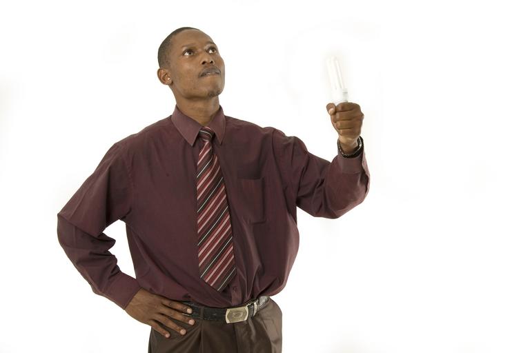 Muž v hnedej košeli drží v ruke žiarovku.jpg
